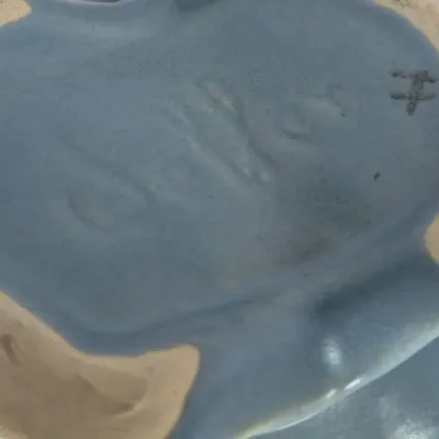 Sale Photo Thumbnail #268: Bottom detail of a vintage blue pottery item showing an incised manufacturer mark and an unglazed foot ring.
