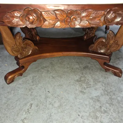 Sale Photo Thumbnail #159: Intricately hand-carved wooden coffee table base featuring detailed floral and leaf relief motifs.