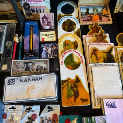 Sale Photo Thumbnail #107: Collection of Wizard of Oz memorabilia, including stationery, magnets, door hangers, pens, novelty license plates, and framed artwork.