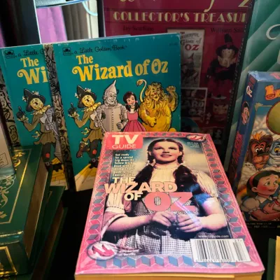 Collection of Wizard of Oz memorabilia, including a Judy Garland TV Guide issue, Little Golden Books, and hardbound collector's books.