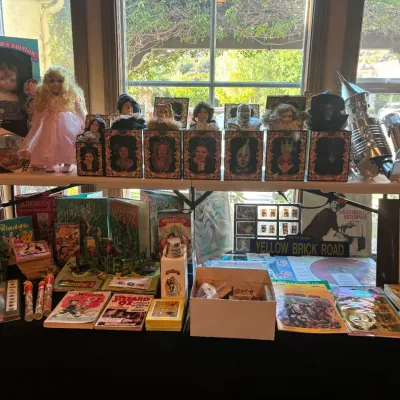 Large collection of vintage Wizard of Oz memorabilia, featuring porcelain character dolls in boxes, collector books, tin foil...