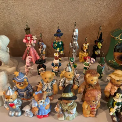 Collection of Wizard of Oz collectibles, including ceramic ornaments, figurines, and teddy bears dressed as characters from the story.