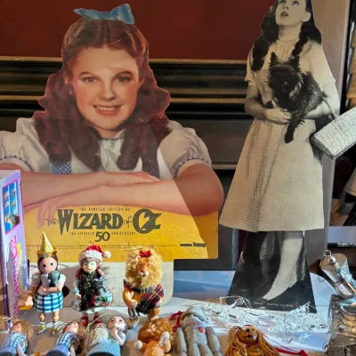 Collection of The Wizard of Oz memorabilia, including cardboard cutout displays, miniature figures, and character ornaments.