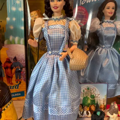 Sale Photo Thumbnail #105: 1990s Barbie as Dorothy from The Wizard of Oz doll displayed out of box with a basket, alongside the original box and small character figurines.