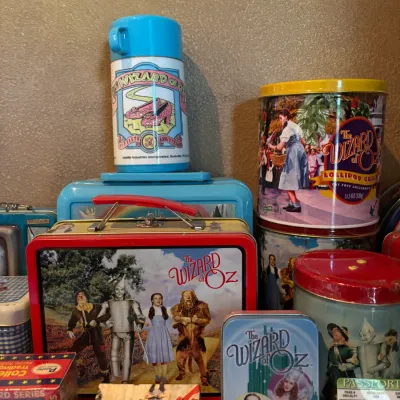 Sale Photo Thumbnail #106: Collection of vintage Wizard of Oz collectibles, including metal lunchboxes, a thermos, popcorn tins, and trading cards.