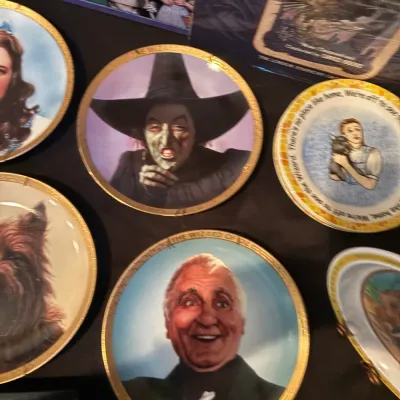 Collection of vintage Wizard of Oz commemorative decorative plates and memorabilia depicting characters like the Wicked Witch of the...