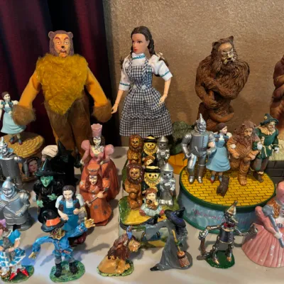 Collection of Wizard of Oz collectibles, including a Barbie Dorothy doll, plush and sculpted figurines, music boxes, and salt and pepper...