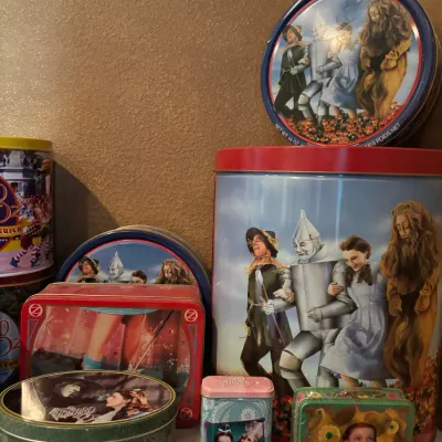 Sale Photo Thumbnail #136: Collection of decorative vintage-style Wizard of Oz collectible tins featuring various scenes and characters from the classic film.