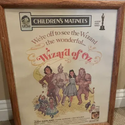 Framed vintage MGM Children's Matinees poster for "The Wizard of Oz" in a light oak wood frame.