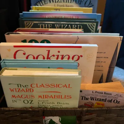 Collection of Wizard of Oz-themed books and other children's literature displayed in a dark brown woven basket.