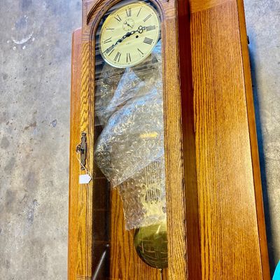 Sale Photo Thumbnail #248: Howard Miller oak wall clock. Might be Seth Thomas (?). Is stamped on face of clock.