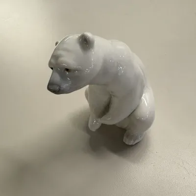LLadro Glossy white porcelain polar bear figurine shown in a seated posture with subtle painted facial details.