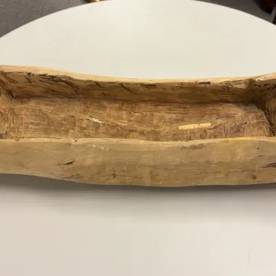 Hand-carved rustic wooden dough trough trough, showing natural grain, knots, and adze marks throughout.
