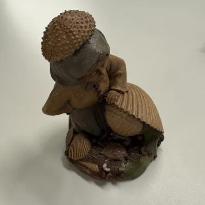 Vintage resin or composition figurine depicting an elderly woman with sea shells and a crab, detailed with textured finishes.