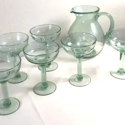 Seven-piece light green hand-blown glassware set, including a pitcher and six matching margarita or coupe glasses featuring subtle floral...