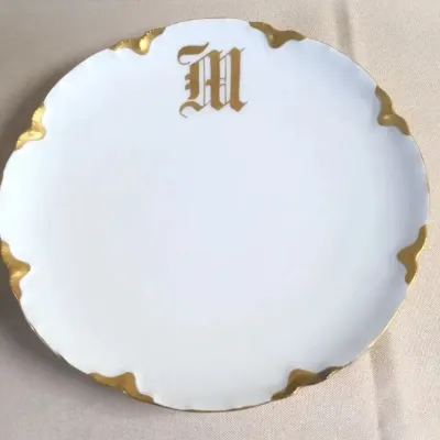 White porcelain decorative plate with scalloped gilded rim and Old English monogrammed gold 'M'.