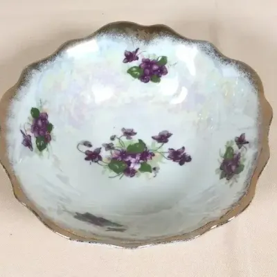 Vintage iridescent porcelain serving bowl featuring hand-painted violet floral motifs and a scalloped gold trim.