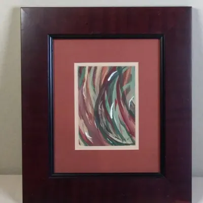 Framed small abstract artwork featuring swirling brushstrokes in green, terracotta, and white, presented with a dark red mat and a wide...