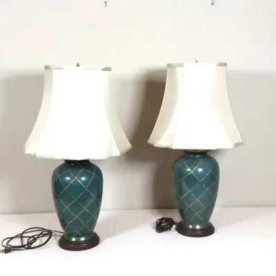 Pair of vintage teal ceramic table lamps with a gold crosshatch design and cream-colored fabric shades.