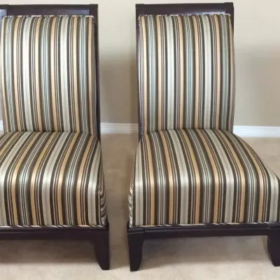 Pair of contemporary armless accent chairs with striped fabric upholstery and dark wood frames.