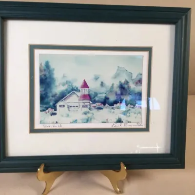 Framed watercolor print titled "Town Hall" by Karl Brown, featuring a winter scene with a red-steepled building set in a dark...