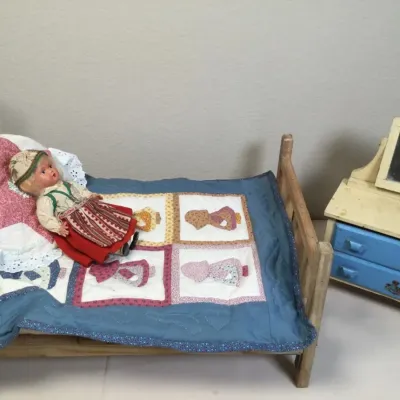 Vintage handmade wooden doll furniture set including a wooden bed frame with a handmade quilt and doll dressed in traditional folk...