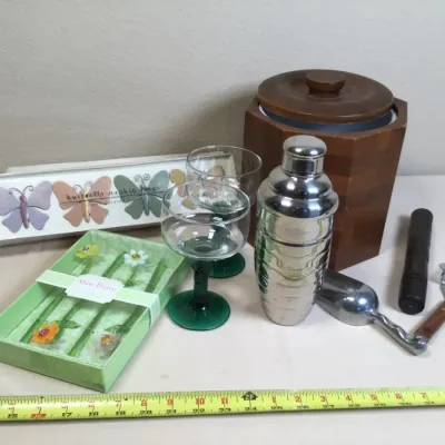 Collection of barware and table accessories, including a wooden ice bucket, stainless steel cocktail shaker with scoop and strainer,...