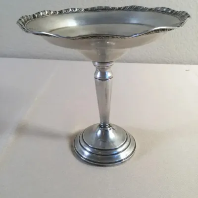 Vintage silver-plated tall compote dish featuring a scalloped, repoussé-trimmed rim and a tapered pedestal base.
