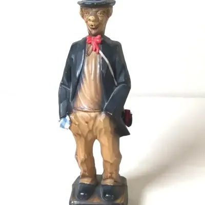 Hand-carved wooden hobofigurine wearing a bowler hat and red bow tie, vintage Italian ANRI style.