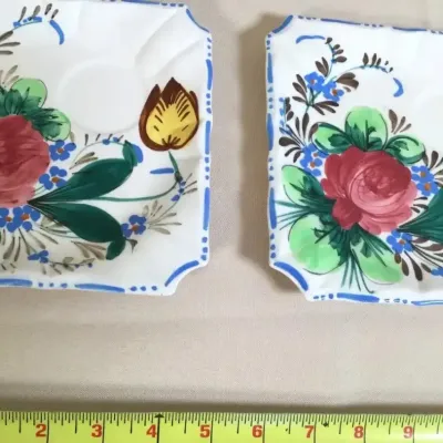 Pair of vintage square ceramic saucers with hand-painted floral motifs including red roses, blue forget-me-nots, and yellow tulips.