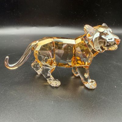 Sale Photo Thumbnail #44: Swarovski crystal tiger figurine featuring golden shadow crystal body accents and clear crystal paws, shown in excellent condition.
