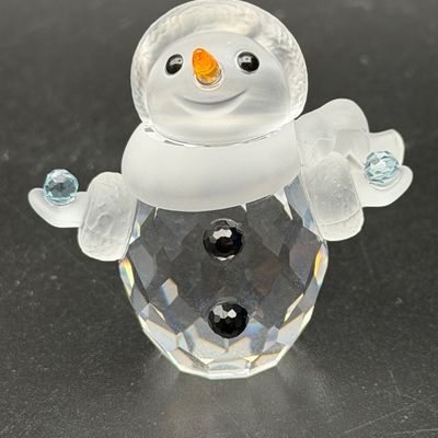 Sale Photo Thumbnail #12: Swarovski crystal snowman figurine featuring frosted glass details, an orange nose, black crystal buttons, and light blue faceted accents in excellent condition.