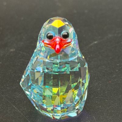 Sale Photo Thumbnail #31: Swarovski faceted crystal penguin figurine featuring an iridescent finish, black glass eyes, and a bright red beak.