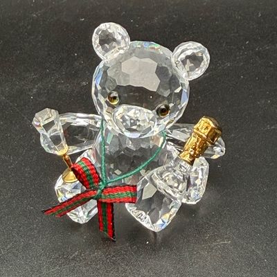 Sale Photo Thumbnail #40: Swarovski crystal teddy bear figurine holding a small horn, adorned with a red and green plaid bow.