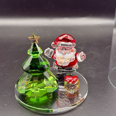 Sale Photo Thumbnail #2: Swarovski crystal Christmas display featuring a green faceted tree, Santa Claus figure, and small gift box on a mirrored glass base.