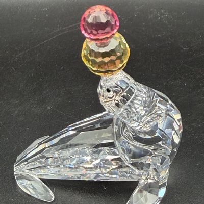 Sale Photo Thumbnail #27: Swarovski crystal sea lion figurine balancing stacked yellow and pink crystal balls on its nose.