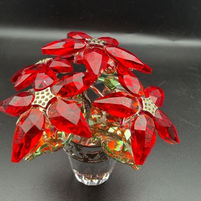 Sale Photo Thumbnail #3: Swarovski crystal Christmas poinsettia figurine in a faceted clear pot, featuring bright red faceted leaves and metallic accents.