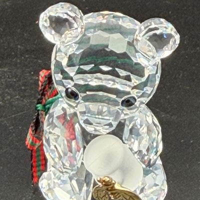 Sale Photo Thumbnail #42: Swarovski crystal Kris Bear figurine holding a honey pot with a gold-tone bee, featuring a green and red ribbon around its neck.