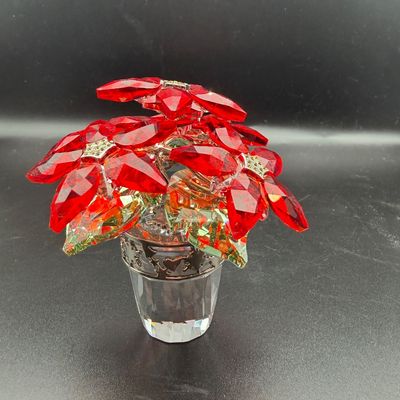 Sale Photo Thumbnail #53: Swarovski crystal potted poinsettia figurine featuring faceted red crystal petals, green leaves, and a clear crystal pot.