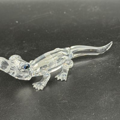 Sale Photo Thumbnail #39: Swarovski clear crystal alligator figurine featuring faceted detailing, smooth tail, and dark blue crystal eyes.