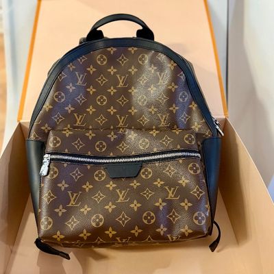 Sale Photo Thumbnail #77: Louis Vuitton Monogram canvas backpack with black leather trim, silver-tone hardware, and front zippered pouch, presented in its original orange box.