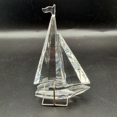 Sale Photo Thumbnail #28: Swarovski clear crystal sailboat figurine with a silver-tone metal display stand.