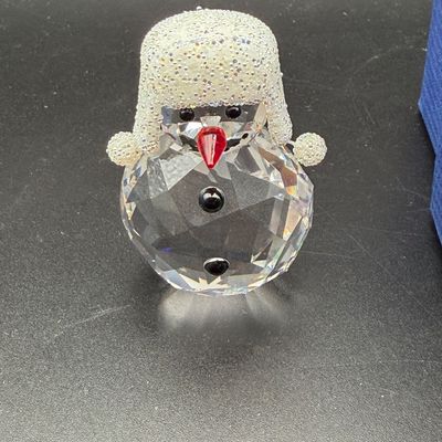 Sale Photo Thumbnail #9: Swarovski crystal snowman figurine featuring a facetted body, frosted glitter winter hat with ear flaps, a red nose, and black crystal eyes and buttons.