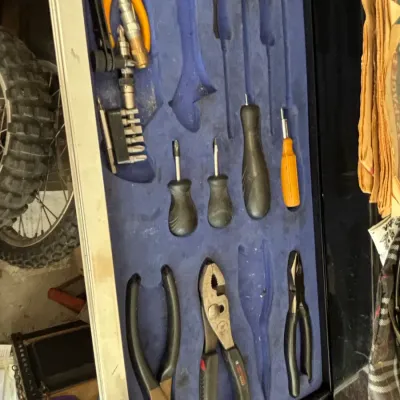 Tool chest drawer filled with various hand tools, including pliers, wire cutters, screwdrivers, and driver bits, arranged in a custom...