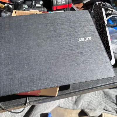 Closed Acer laptop with a textured dark gray lid and white logo, showing minor wear on the exterior.