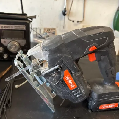Warrior cordless jigsaw with battery pack attached, showing light wear from use.