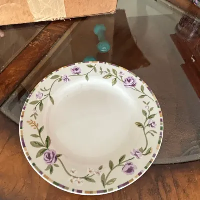Ceramic dinner plate featuring a floral border of purple roses and green vines with a patterned rim.