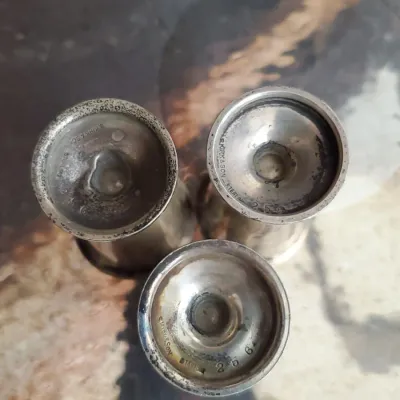 Underside view of three S. Kirk & Son sterling silver items, showing maker's hallmarks and model number 256.