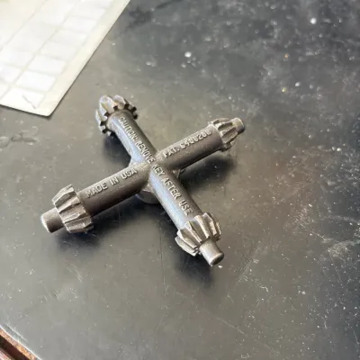 Vintage 4-way universal drill chuck key stamped 'MADE IN USA', showing light surface wear.