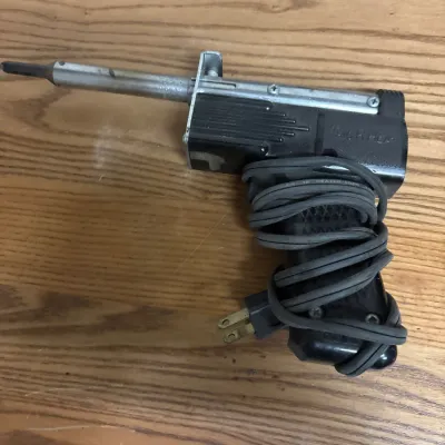 Vintage Theraputic-Heat soldering iron gun with attached power cord wrapped around the handle, showing minor surface wear.